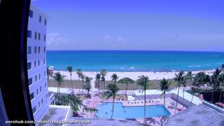 Meztelenül a miami tengerparton, hotelszobai ablaknál az óceánra meredve